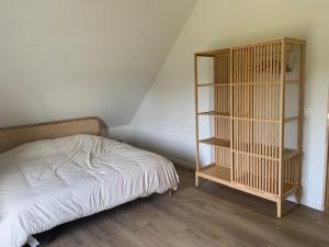 a bedroom with a bed and a book shelf at Vakantiewoning - Perspektiv in Kortemark