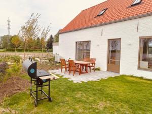 a barbecue grill in a yard next to a house at Vakantiewoning - Perspektiv in Kortemark