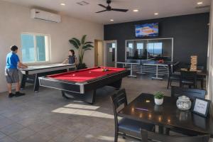 two people playing pool in a room with pool tables at Updated Beachfront Condo on Sandy Beach, Las Palmas Resort, 24hrs Security, Free Parking, Free Wi-Fi in Puerto Peñasco
