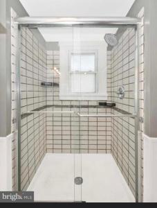 a shower with a glass door in a bathroom at Need a room i got you in Frederick