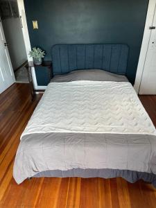 a large bed with a blue headboard in a bedroom at Need a room i got you in Frederick