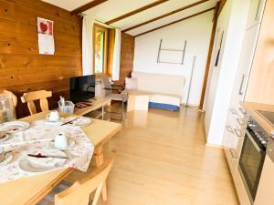 a room with wooden walls and tables and a kitchen at Sohlerhof in Eichenberg
