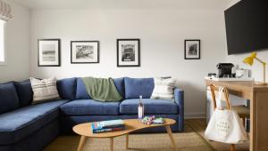 a living room with a blue couch and a table at The Penny Lane in Hampton Bays