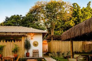 a house with a thatched roof and a fence at Vila Inca in Alto Paraíso de Goiás