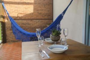 a wooden table with wine glasses and plates and a hammock at Chalé Jenipapo in Serra do Cipo +60 photos
