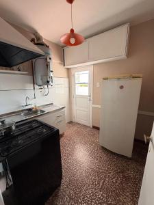 a kitchen with a stove and a refrigerator in it at Hospedajes Edén in La Falda