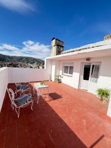 a patio with chairs and a table on a house at Hospedajes Edén in La Falda