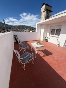 a patio with two chairs and a table on a house at Hospedajes Edén in La Falda +2 photos
