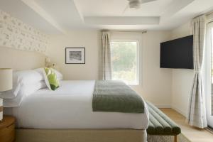 a bedroom with a white bed and a window at The Penny Lane in Hampton Bays