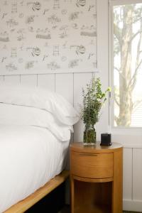 a bedroom with a bed and a vase of flowers on a table at The Penny Lane in Hampton Bays +30 photos