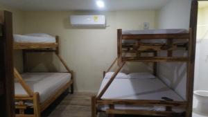 a small room with two bunk beds and a fan at Hotel Y Restaurante Verano Azul in Moñitos