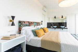 a bedroom with a large bed with yellow pillows at Vanity Suite in Sorrento