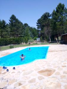 a person swimming in a swimming pool on a beach at La cabaña de Magui in Riópar
