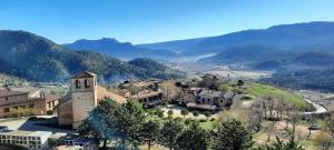 an aerial view of a house on a hill with mountains at La cabaña de Magui in Riópar