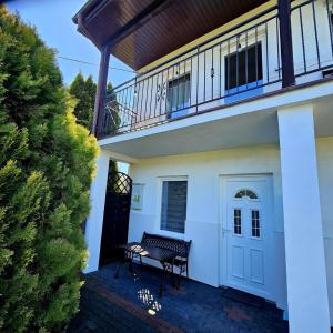 a porch of a house with a bench and a balcony at Fox pokoje-apartament-domki in Władysławowo
