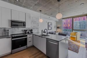 a large kitchen with white cabinets and appliances at Sentral Sol Modern in Phoenix