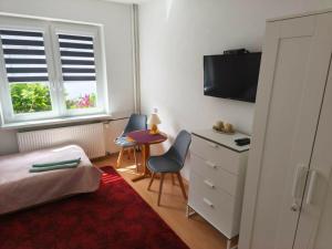 a bedroom with a bed and a desk and a tv at Pokoje gościnne in Międzyzdroje