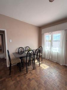 a dining room with a table and chairs and a window at Hospedajes Edén in La Falda