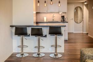 a kitchen with black stools at a kitchen counter at Newly built souterrain apartment in Älvsbacka in Skellefteå