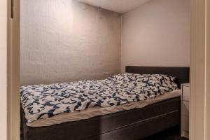 a bedroom with a bed with a black and white comforter at Newly built souterrain apartment in Älvsbacka in Skellefteå