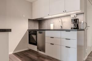a kitchen with white cabinets and a sink at Newly built souterrain apartment in Älvsbacka in Skellefteå
