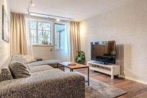 a living room with two couches and a flat screen tv at Newly built souterrain apartment in Älvsbacka in Skellefteå