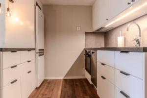 a kitchen with white cabinets and stainless steel appliances at Newly built souterrain apartment in Älvsbacka in Skellefteå +1 photo