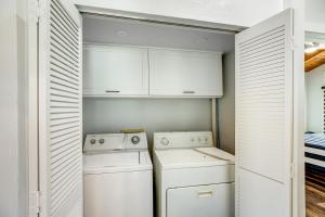 a laundry room with white cabinets and a washer and dryer at BP05FLR Tradewinds Treat in Big Pine Key