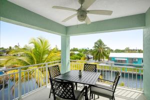 a balcony with a table and chairs and a view of the water at BP04FLR Sunset Villa in Big Pine Key