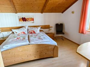 a bedroom with a wooden bed and a chair at Sohlerhof in Eichenberg