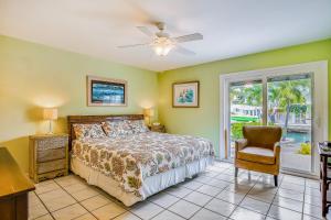 a bedroom with a bed and a chair and a window at BC277FLR Sapphire Sabbatical in Key West