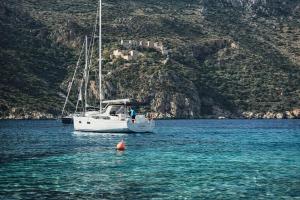 a white boat in the water near a mountain at Castello in Porto Kagio +5 photos