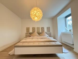 a bedroom with a large bed and a chandelier at Apartment Hornberg-Melisa in Hornberg