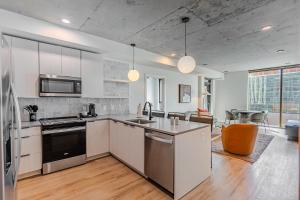 a kitchen with stainless steel appliances and a living room at Sentral Sol Modern in Phoenix