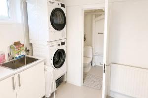 a laundry room with a washer and dryer next to a sink at Boende i Vimmerby in Vimmerby