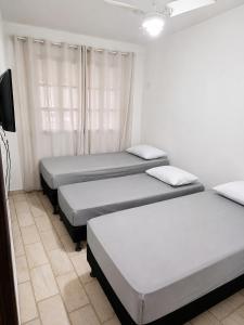 a group of three beds in a room at Sossai Hostel in Vitória +10 photos