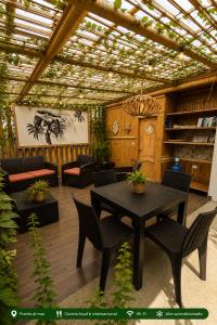 a patio with a table and chairs and a couch at Casita Madame - Frente al Mar con Desayuno Gourmet in Puerto López