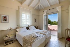 a bedroom with two beds and a balcony at Andromeda Villa in Tranakatika +37 photos