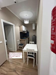 a small kitchen with a white table and chairs at Titti's Room in Casteldaccia