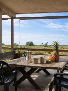 a wooden table with a pineapple and fruit on a porch at Casa Chukum - Retreat House - Agua Blanca in Playa Agua Blanca