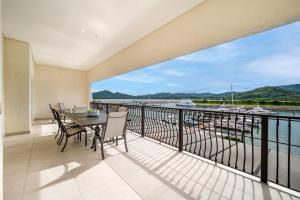 a balcony with a table and chairs and a view of the water at Luxury Marina Suite 2BR in Playa Flamingo