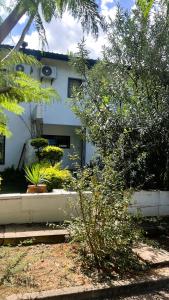 a white house with plants in front of it at 29 Village Place in Gaborone