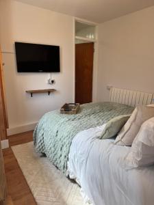 a bedroom with a bed with a flat screen tv on the wall at The Hidden Gem in Mablethorpe