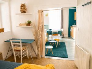 a room with a table and chairs and a dining room at Appartement bleu in Eymoutiers