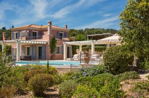 a villa with a swimming pool in a garden at Andromeda Villa in Tranakatika