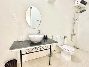 a bathroom with a sink and a toilet and a mirror at Villa Rosa HueS in Thôn An Hòa +25 photos