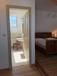 a bedroom with a bed and a table and a window at Chalupa na Brdech in Obecnice