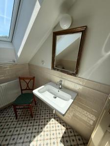a bathroom with a sink and a mirror and a chair at Chalupa na Brdech in Obecnice