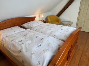 a bed with a wooden frame with a white comforter at Chalupa na Brdech in Obecnice