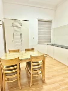 a dining room with a wooden table and chairs at Villa Rosa HueS in Thôn An Hòa